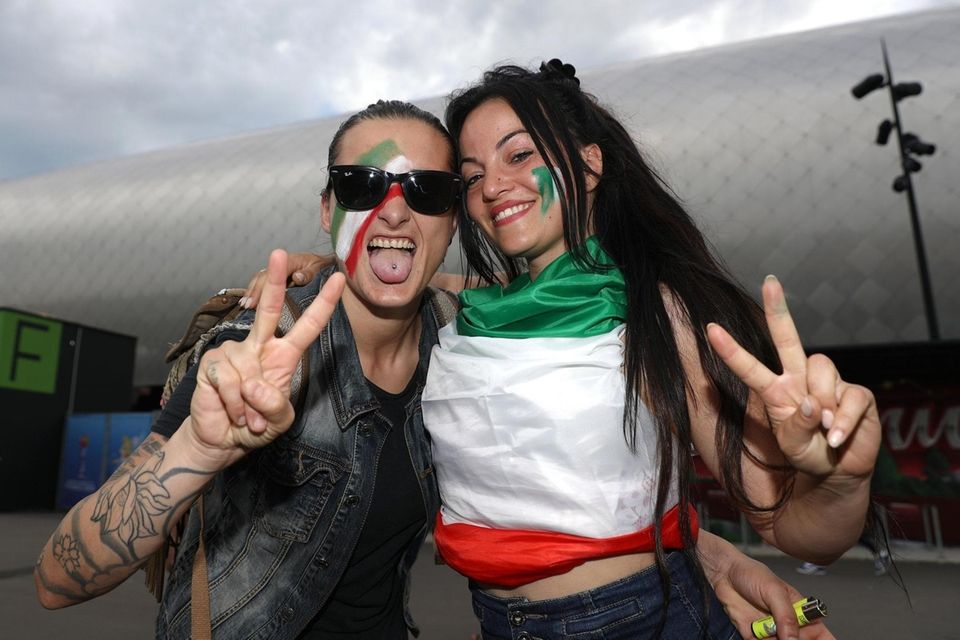 Fans pose outside the stadium prior to the
