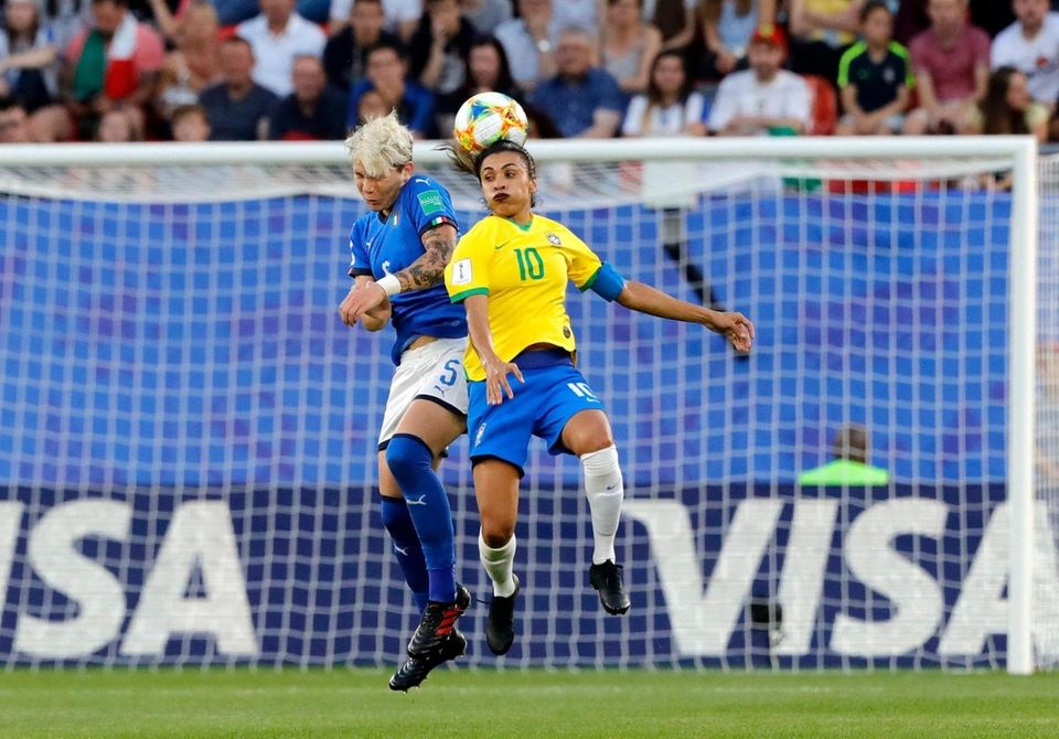 Italy's Elena Linari, left, jumps for the ball