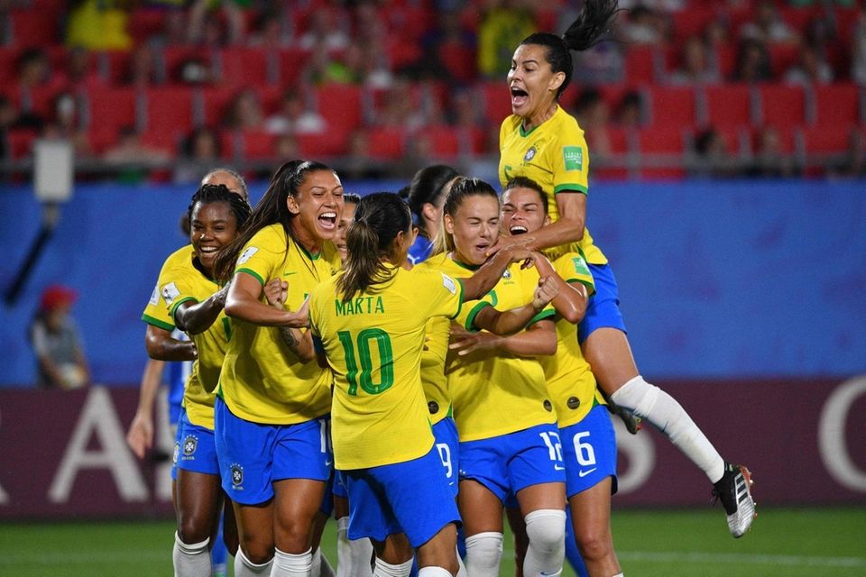 Brazil's forward Marta (C) is congratulated by teammates
