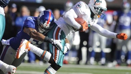 Michael Boley tackles Miami Dolphins running back Reggie