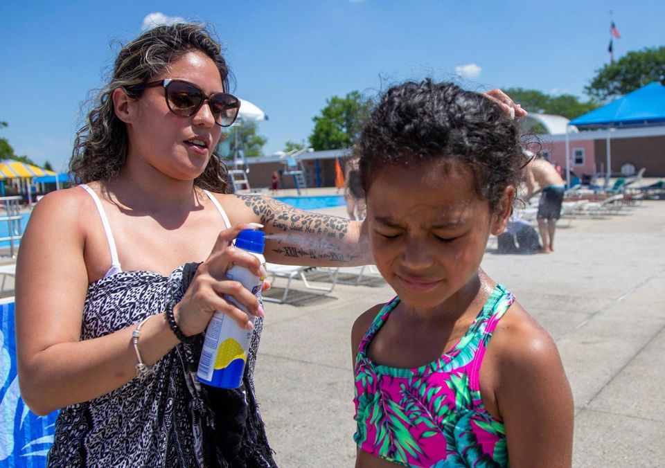 Fran puts sunblock on her daughter Annabelle Durden,