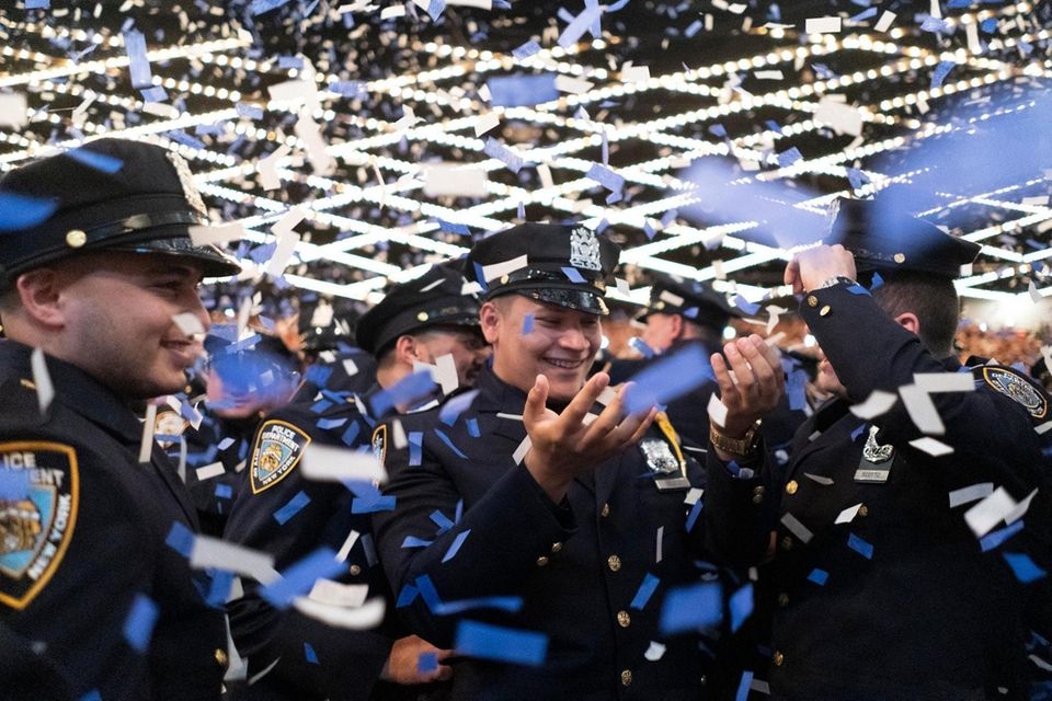 New NYPD police officers celebrate during their academy