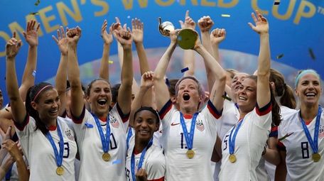 Megan Rapinoe lifts a trophy after the United