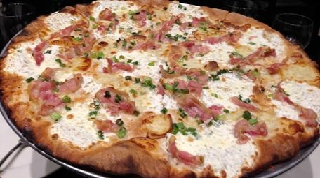 The white pizza topped with fresh mozzarella, scallions,