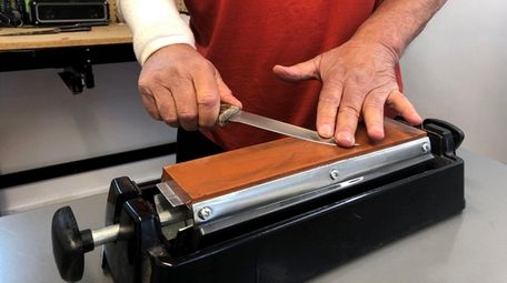 Richard De Vito, Sr. finishes sharpening a knife