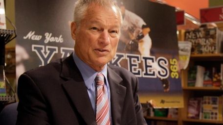 Former New York Yankees pitcher Jim Bouton signs