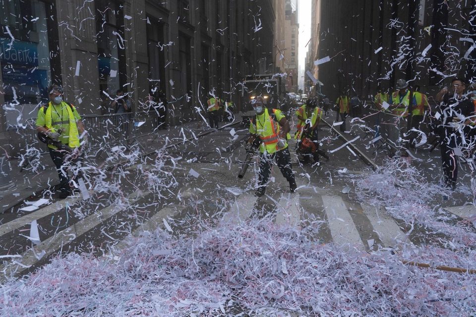 Members of the Department of Sanitation use brooms
