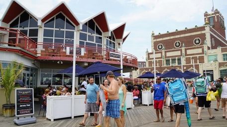 Visitors stroll the boardwalk at Asbury Park in