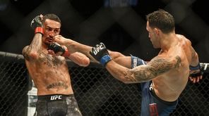 Max Holloway, left, blocks a kick from Frankie