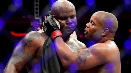 Daniel Cormier, right, talks with Derrick after defeating