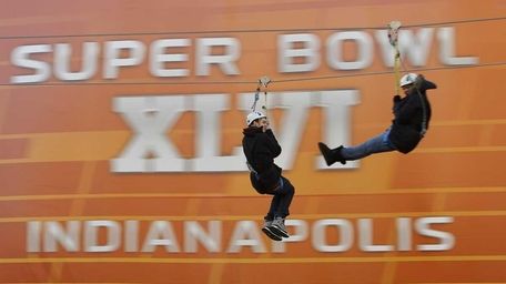 Fans ride a zip line during the NFL