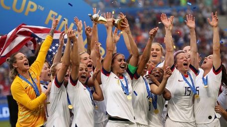 United States' Alex Morgan holds the trophy celebrating