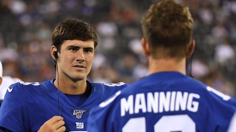 Giants quarterback Daniel Jones talks to quarterback Eli