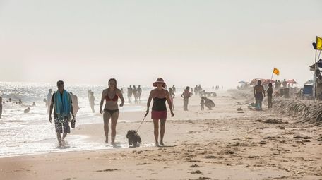 People walk along the beach at Kismet on