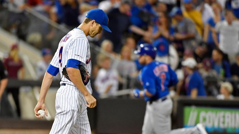 Jacob deGrom walks back around the mound as