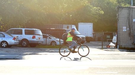 A man rides his bicycle along Fifth Avenue
