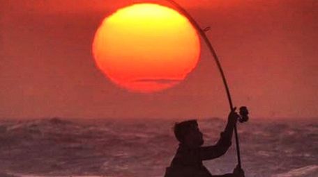 A surf caster fishing for striped bass at