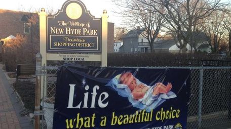 An anti-abortion sign hangs on a fence owned