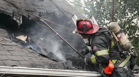 A firefighter battles a blaze at a home