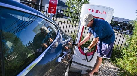 Jeff Wheeler, of Amityville, plugs in his Tesla
