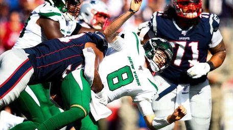 Luke Falk of the Jets is taken down