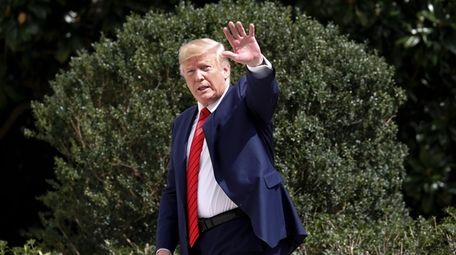 President Donald Trump gestures towards members on the