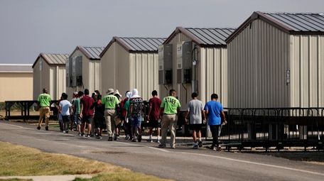 Staff escort immigrants to class at the U.S.