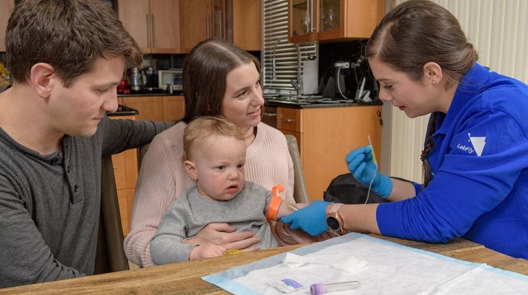Northwell Health Labs phlebotomist Dina Durdu, right, makes