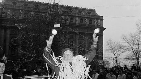 Casey Stengel, covered in ticker tape, tosses plastic