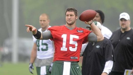 Quarterback Tim Tebow #15 directs a wide receiver