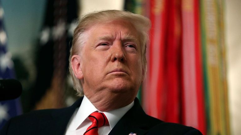 President Donald Trump listens to a question as