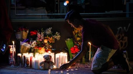 Gabriel DeGuzman, 15, of Oceanside, lights a candle