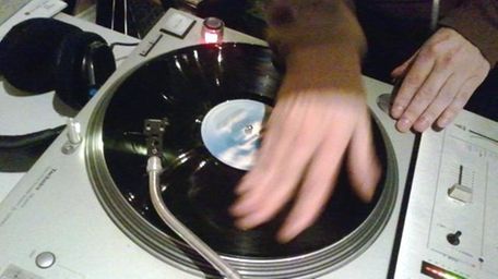 A DJ mixes with a vinyl record. (Feb.