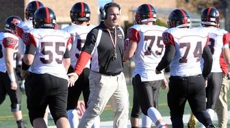 A Plainedge football coach congratulates players as they