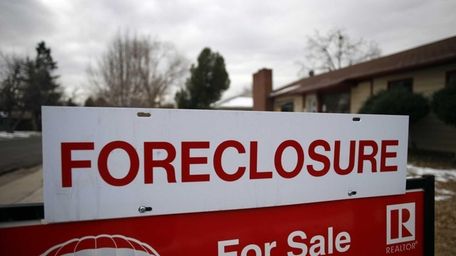 A foreclosure sign sits on top of a