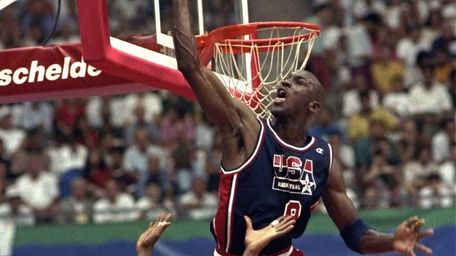 USA's Michael Jordan sails high above teammate Magic