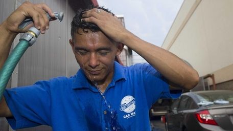 Bambino Ramirez cools himself down while washing cars