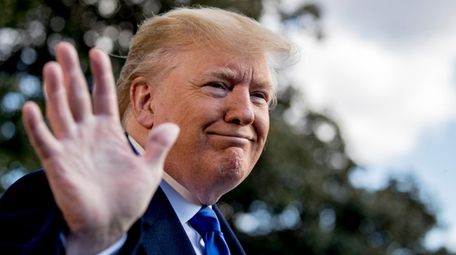 President Donald Trump smiles while speaking to reporters