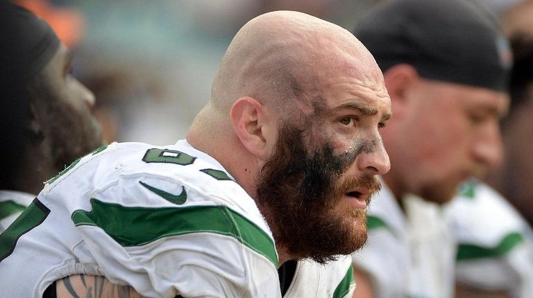 Jets offensive guard Brian Winters, left, sits on