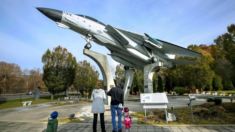 A family looks at the F-14 fighter jet