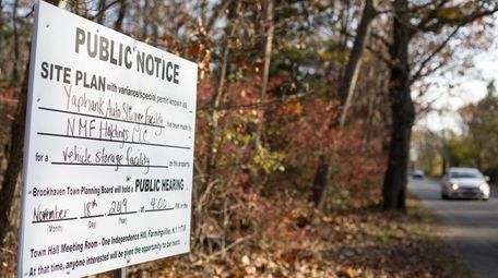 A public notice sign announces a hearing will