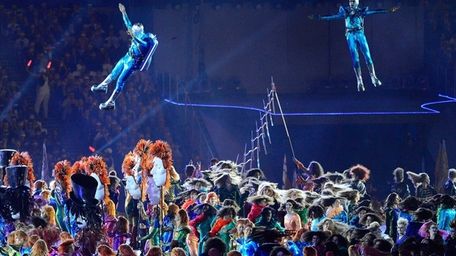 Performers in futuristic costumes perform during the opening