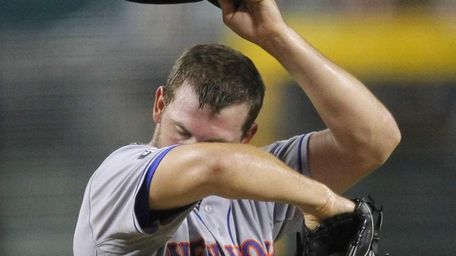 Mets pitcher Jonathon Niese wipes his face after