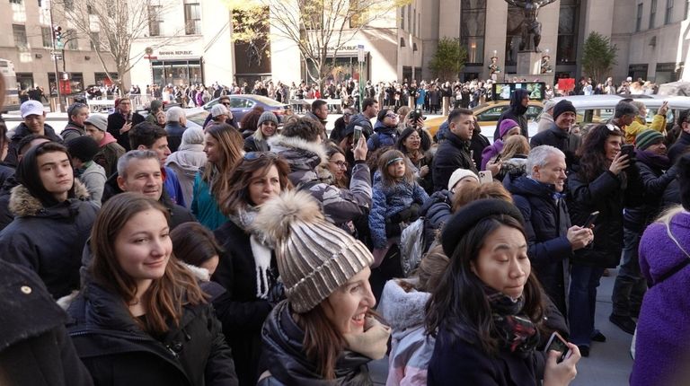 Pedestrians crowd the streets and sidewalks around Rockefeller