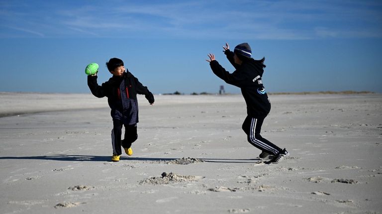 Roger Yi, 10, of Woodbury, left, plays with