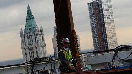 A construction worker walks near the eastern face