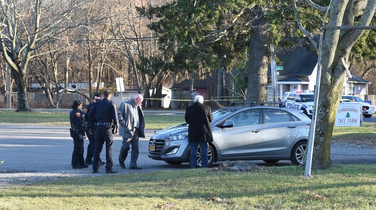Investigators probe a vehicle in which a man