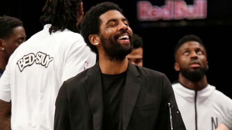 Nets guard Kyrie Irving, center, jokes with forward