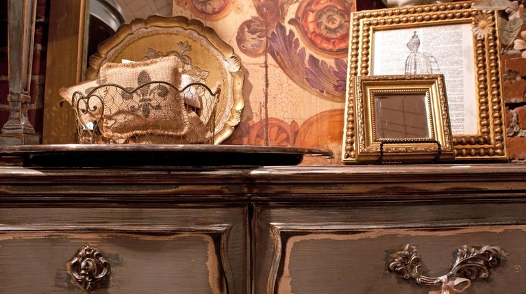 An antique dresser with French décor accents.