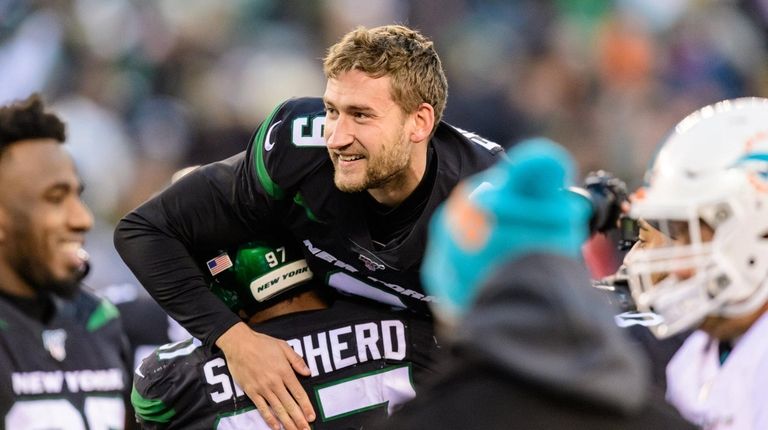 Jets kicker Sam Ficken is hoisted into the